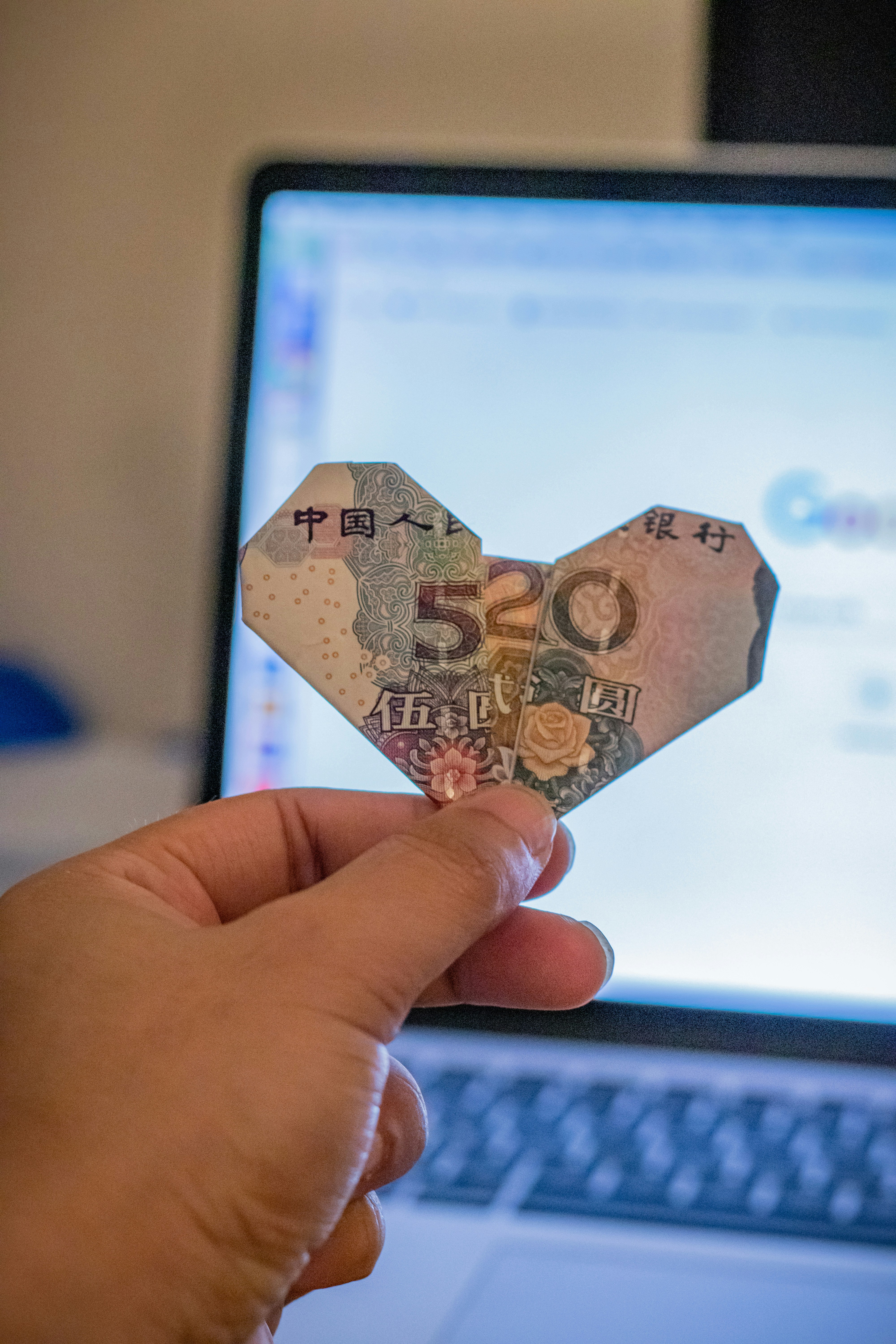 Kineska novčanica savijena u obliku srca sa brojevima 520